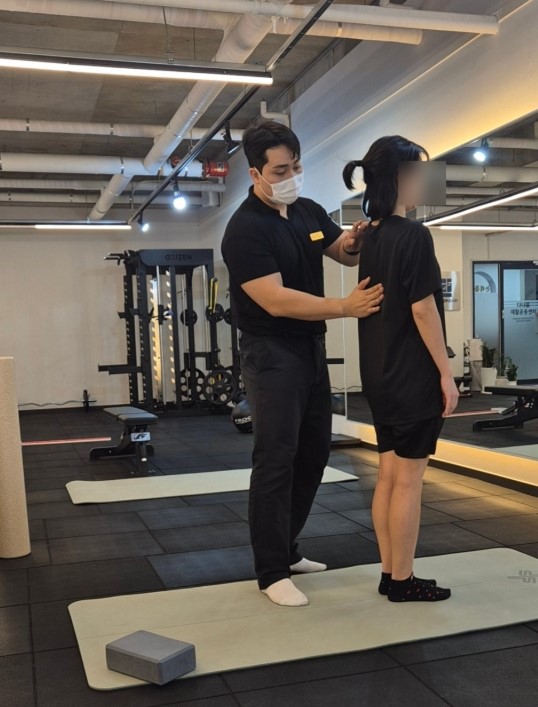 지도자의 도움을 받으며 한발 지지 동작을 연습하는 모습