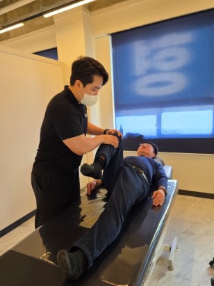 운동대에 옆으로 누운 자세에서 움직임을 확인하는 지도자